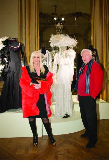 Enfundada en un vestido al cuerpo de Versace que acompañó con botas altas con puntera dorada, Su posa frente a un traje blanco realizado íntegramente en encaje que usó en 1979, junto a ella, el gran Horace Lannes