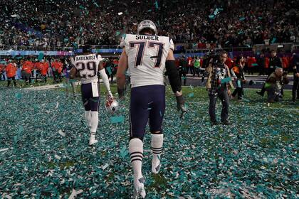 Derrotados, Johnson Bademosi y Nate Solder salen del campo después del Super Bowl 52 contra los Philadelphia Eagles