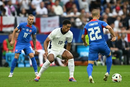England's midfielder #10 Jude Bellingham fights for the ball with Slovakia's midfielder #22 Stanislav Lobotka during the UEFA Euro 2024 round of 16 football match between England and Slovakia at the Arena AufSchalke in Gelsenkirchen on June 30, 2024. (Photo by OZAN KOSE / AFP)�