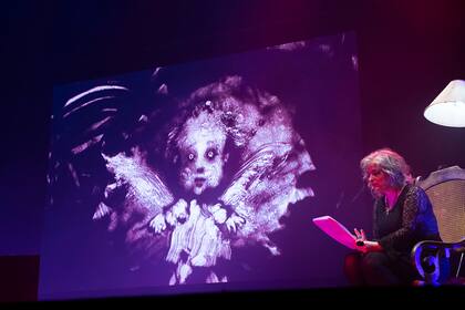 Enriquez y, de fondo, "Angelita", el fantasma tenebroso de uno de sus cuentos del libro "Los peligros de fumar en la cama"