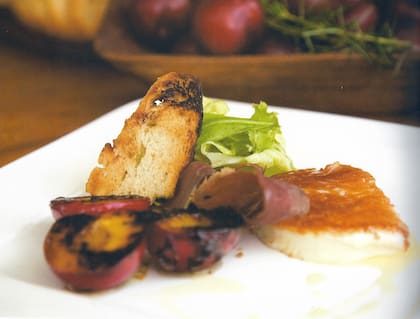 Ensalada de ciruelas asadas y queso de cabra grillado sobre bruschetta con mézclum de verdes, creación de Dolli Irigoyen