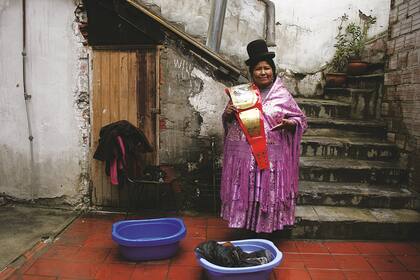 Entre dos mundos. En su casa, entre los utensilios del trabajo doméstico, Carmen Rosa muestra el cinturón rojo y dorado de campeona