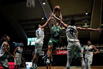 Entre gigantes: Jano Martínez va hacia el aro mientras dos rivales, de mayor envergadura, intentan lo imposible de frenarlo