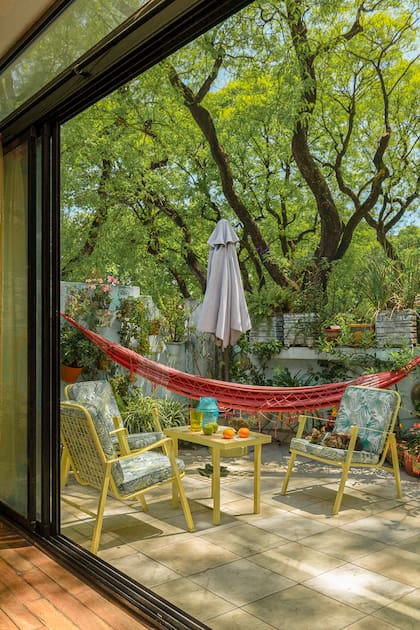 Entre las copas de las tipas un living de exterior que se usa todo el año.