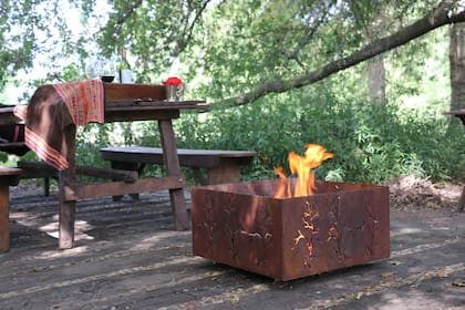 Entre los modelos del Estudio Stewart-Murray, 'El Arrayán', Las llamas se ven a través de las ramas caladas en la chapa. Por sus medidas (60x60cm), es fácil de mover.
