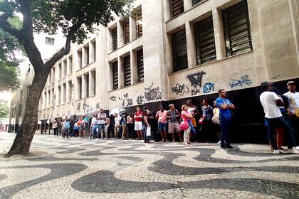 Entre vendedores de mate y bizcochos, la gente que hace fila para cobrar el seguro de desempleo en la sede regional del Ministerio de Trabajo en Río de Janeiro comparte sus dramas