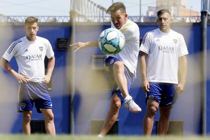 Carlos Tévez remata en el entrenamiento de Boca, ante la mirada de Nicolás Capaldo y Ramón Ábila