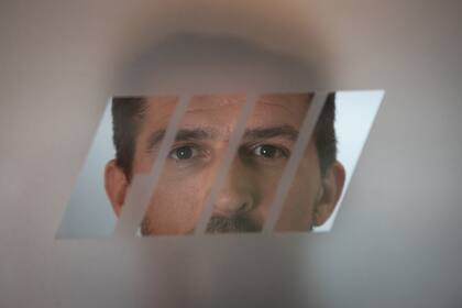 La mirada de Matías Rossi a través del logo de la puerta de acceso a su oficina en Del Viso; el piloto reclama cambios técnicos y terminar con las penalidades para reconquistar al público del automovilismo