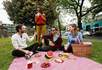 Martín Drucaroff (centro) y sus amigos disfrutan de una canasta deli en el bulevar García del Río