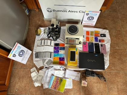 Equipos y elementos secuestrados en el allanamiento en Ituzaingó: máquinas para copiar bandas magnéticas, dispositivos de grabado en relieve, tarjetas clonadas y en blanco, celulares, una notebook y documentación vinculada a la maniobra