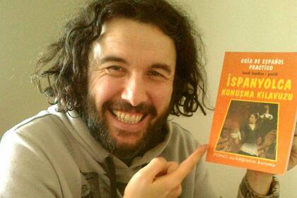 Ergün Demir con una guía para aprender español, antes de su llegada a la Argentina