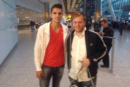 Erik Lamela junto a un fan en su llegada a Londres