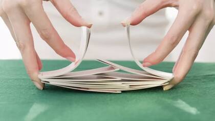 Es un modo muy común barajar las cartas mezclándolas como una "cremallera" haciendo una suerte de puente, como en la foto.