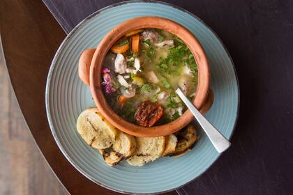 Escabeche de conejo con torrontés, en pan de campo grillado con oliva riojano.