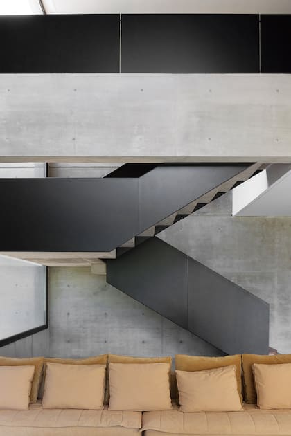 Escalera de hormigón con baranda de chapa pintada (Estudio Karina Kreth).