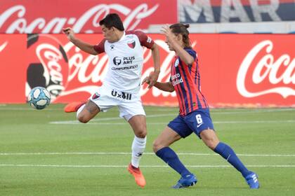 El Pulga Rodríguez pelea por la pelota con Federico Gattoni; San Lorenzo y Colón se miden en el Nuevo Gasómetro.