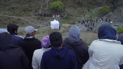 Escena de la reconstrucción del asesinato de Javier Chocobar, donde se ve al equipo del Ministerio Público, los imputados, y a la comunidad de Chuschgasta observando.