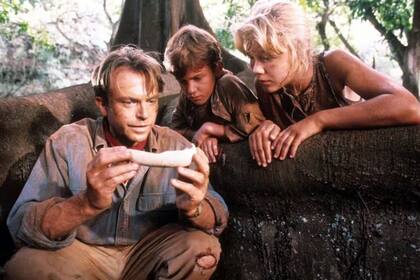 Escena de Parque Jurásico con Alan Grant (Sam Neill) interactuando con los nietos del dueño del parque