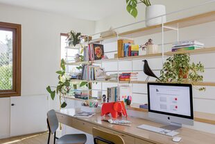 Escritorio flotante y estantes hechos a medida en guatambú. Sillas ‘Te’, de multilaminado y estructura de hierro (Estudio Te). Objetos decorativos (Lola Goldstein). Ventanas de PVC foliado símil madera (Tecnoaberturas).
