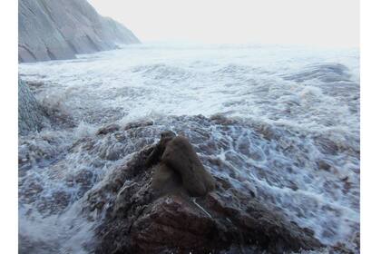 Escultura de la mujer que representa la Naturaleza, frente un mar embravecido