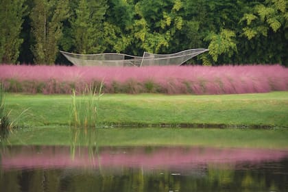 Escultura en un jardín, rodeada de Muhlenbergia capillaris.