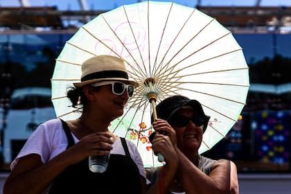 Espectadoras se protegen del fuerte sol en Australia