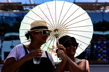 Espectadoras se protegen del fuerte sol en Australia