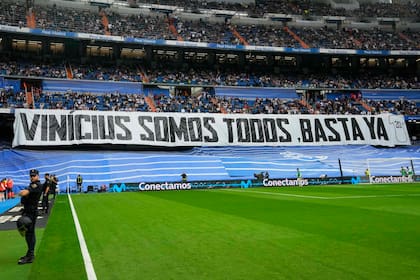 Espectadores despliegan la pancarta con la frase "Vinicius Somos Todos, Basta Ya" en el estadio Santiago Bernabéu durante el partido entre el Real Madrid y el Rayo Vallecano por la Liga de España, el miércoles 24 de mayo de 2023. (AP Foto/Manu Fernández)