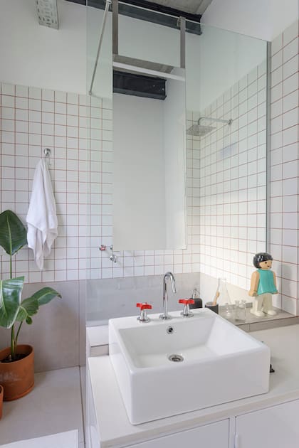 Espejos colgantes y vanitory de chapa diseñados por el Estudio y ejecutados por Lucero Taller. Mesada de Silestone con grifería FV. Revestimiento de azulejos de 10x10cm (Acuarela) con juntas oscuras.