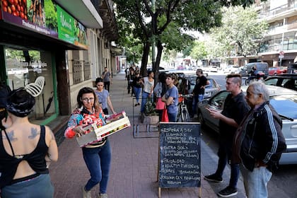 Espera para ingresar a una verdulería sobre la Av. Díaz Vélez; muchos negocios permiten hacer pedidos por Whatsapp para ir sólo a retirarlos