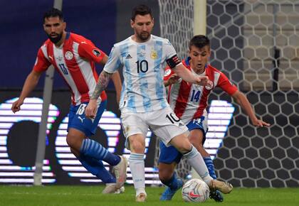 Espínola y Cubas custodian los movimientos de Messi; el capitán no iba a comenzar en la formación titular, pero finalmente el DT Scaloni cambió de planes y eso alteró buena parte de la alineación