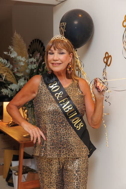 Espléndida Mora a sus ochenta con un conjunto de estampa animal, la tiara y la banda con que sus amigas la “coronaron”