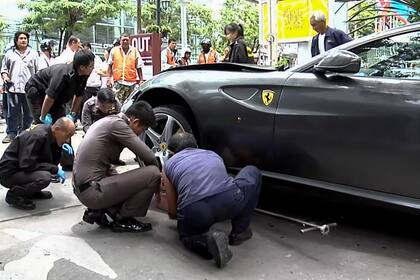Esta captura de video tomada el 3 de septiembre de 2012 muestra a la policía inspeccionando el auto Ferrari perteneciente al heredero de Red Bull, en Bangkok