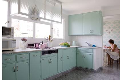 Esta cocina de los 50 se actualizó con un esmalte satinado sobre sus muebles y un lindo empapelado en su comedor diario. Fresca y linda para pasar la tarde