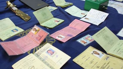 Esta foto de 2001, muestra tarjetas de identidad, pasaportes y licencias de conducir falsas que fueron encontradas en un operativo policial en Madrid