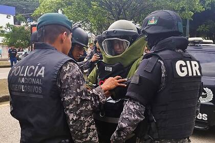 Esta foto de archivo difundida por la Policía Nacional de Ecuador muestra a agentes de policía preparándose para llevar a un hombre con explosivos atados a su cuerpo en Guayaquil, Ecuador, el 30 de marzo de 2023.