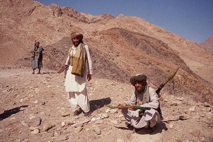 Esta foto de archivo tomada el 14 de octubre de 2001 muestra a combatientes talibanes posando en la cima de una colina cerca de Jalalabad.