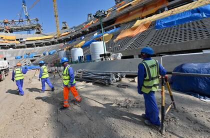 Esta foto de archivo tomada el 20 de diciembre de 2019,muestra a trabajadores de la construcción en el Estadio Lusail de Qatar, a unos 20 kilómetros al norte de la capital Doha.