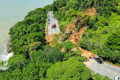 Esta foto difundida por la Defensa Civil de Ubatuba muestra la carretera SP-55 bloqueada por un deslizamiento de tierra en el municipio de Ubatuba, costa norte del estado de Sao Paulo, Brasil, el 19 de febrero de 2023. 