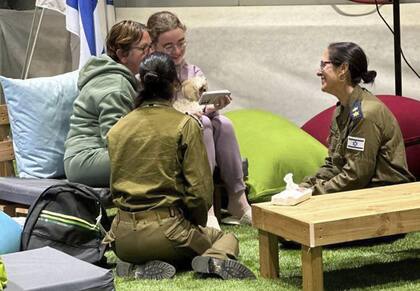 Esta foto facilitada por GPO muestra a Gabriela y Mia Leimberg, en la parte trasera, hablando con su familia desde un punto de encuentro en territorio israelí tras ser liberadas por Hamás, el martes 28 de noviembre de 2023. 