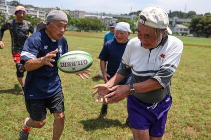 Esta foto tomada el 28 de junio de 2023 muestra al jugador de rugby Yasutake Oshima (derecha), de 85 años, participando en una sesión de entrenamiento de rugby para su equipo senior de mayores de 70 años, en el Fukasawa Multi-Purpose Sports Plaza en Kamakura, prefectura de Kanagawa, en Japón