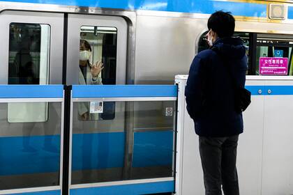 Esta foto tomada en Tokio el 14 de febrero de 2021 muestra a una mujer saludando a su novio mientras sale de la estación en tren