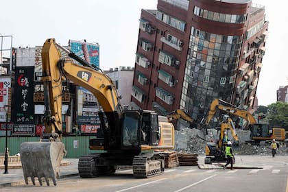 Esta foto tomada por la Agencia Central de Noticias de Taiwán (CNA) el 4 de abril de 2024 muestra bulldozers siendo utilizados para retirar escombros cerca de un edificio dañado en Hualien, después de que un importante terremoto golpeara el este de Taiwán.