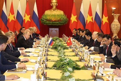 Esta foto tomada y difundida por la Agencia de Noticias de Vietnam (VNA) el 20 de junio de 2024 muestra al secretario general del Partido Comunista de Vietnam, Nguyen Phu Trong (4º dcha.), asistiendo a una reunión con el presidente de Rusia, Vladímir Putin (centro izq.), en Hanoi.