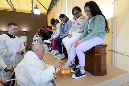 Esta foto tomada y distribuida el 28 de marzo de 2024 por The Vatican Media muestra al Papa Francisco realizando el "Lavado de pies" de las reclusas durante una visita privada a la prisión para mujeres de Rebibbia en Roma como parte del Jueves Santo