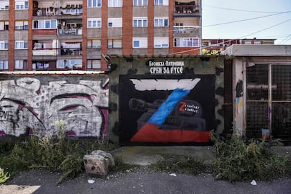 Esta fotografía tomada el 19 de septiembre de 2022 muestra un mural en el que se lee "Serbios para los rusos, para la libertad, para la victoria" y en el que aparece un tanque con la letra "Z", la insignia táctica de las tropas rusas en Ucrania, en el norte de Mitrovica, donde vive una mayoría étnica serbia.