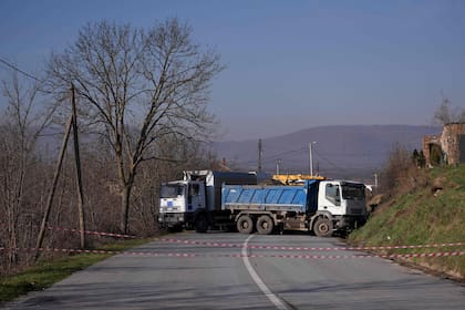 Esta fotografía tomada el 26 de diciembre de 2022 muestra una carretera atrincherada con camiones por los serbios en el pueblo de Rudare, cerca de la ciudad de Zvecan.