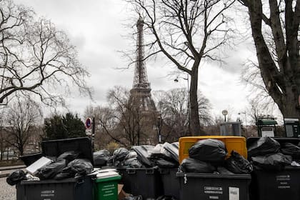 Esta fotografía tomada en París, el 13 de marzo de 2023, muestra residuos domésticos cerca de la Torre Eiffel que se han ido acumulando en la acera