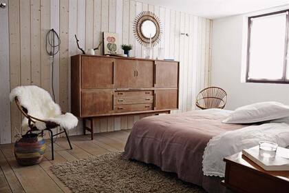 Esta habitación tiene una pared revestida con tablas de pino y pisos de incienso teñido. Mueble vintage comprado en un mercado de pulgas, junto al dúo de sillones y la alfombra heredados