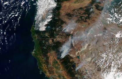 Esta imagen satelital muestra los incendios forestales en el norte de California y Oregon el miércoles 21 de julio de 2021